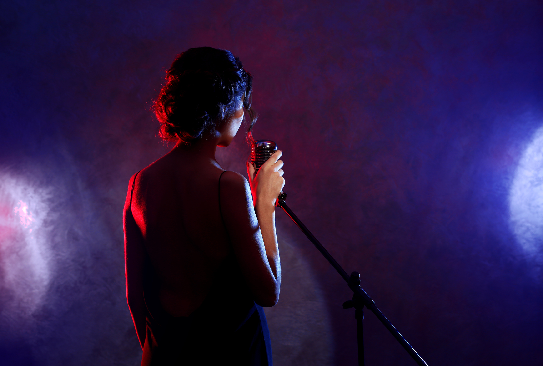 Beautiful Brunette Woman Singing on Purple Background, Backside View